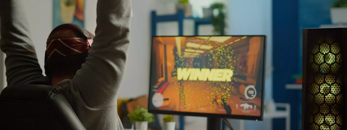 นักเล่นเกมชายมีความสุขหลังแข่งชนะเกมออนไลน์