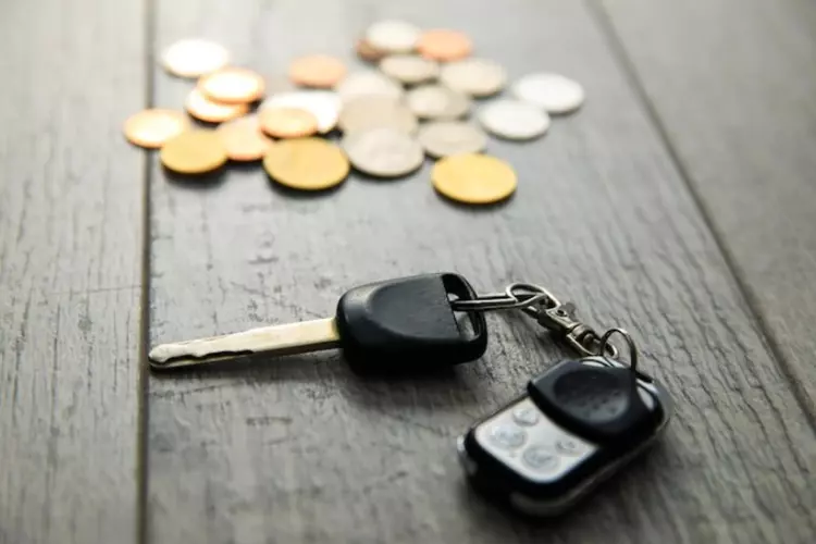 กุญแจรถและเหรียญบนโต๊ะไม้ 