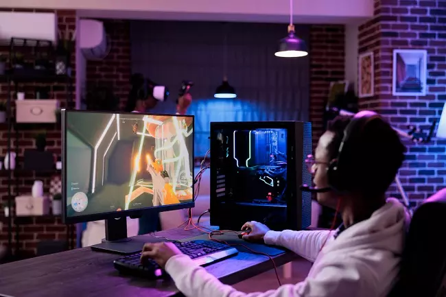 ผู้ชายนั่งเล่นเกมคอมพิวเตอร์ PC 