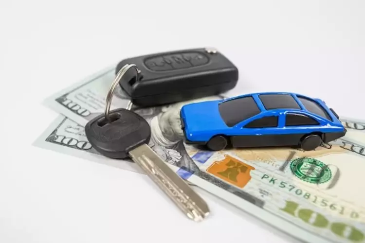 รถของเล่นและกุญแจรถวางบนธนบัตร 