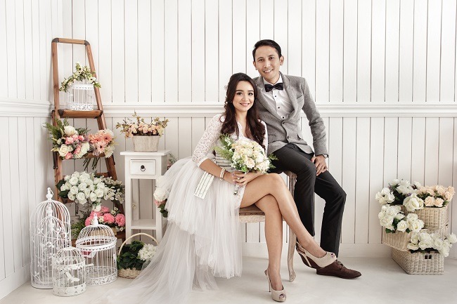 คู่บ่าวสาวยิ้มอย่างมีความสุข