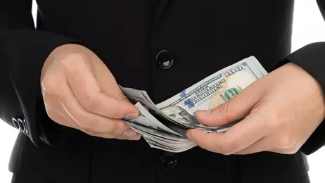 ผู้ชายถือเงินดอลลาร์