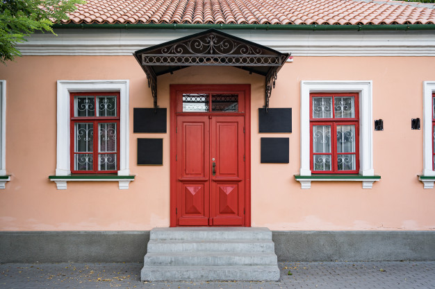 บ้านสีโอรสพร้อมประตูและหน้าต่างสีแดง