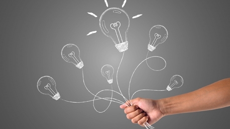 ใช้มือจับลูกโป่งสัญลักษณ์หลอดไฟ