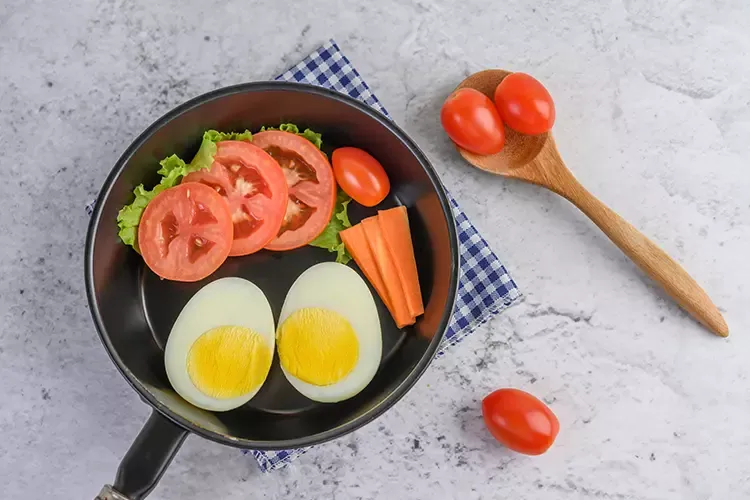 ไข่ต้ม แครอท และมะเขือเทศอยู่ในกระทะ