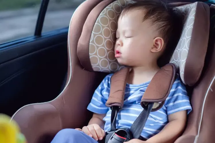 เด็กผู้ชายวัย 1 ขวบ กำลังนอนในคาร์ซีทบนรถยนต์ 