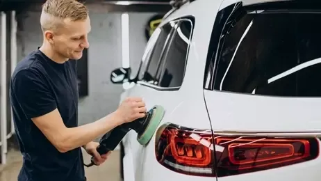 ผู้ชายขัดรถด้วยเครื่องขัด