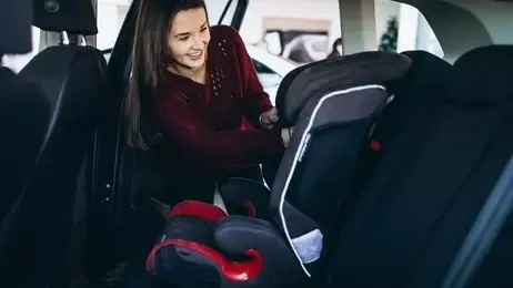 ผู้หญิงกำลังติดตั้งคาร์ซีทในรถ