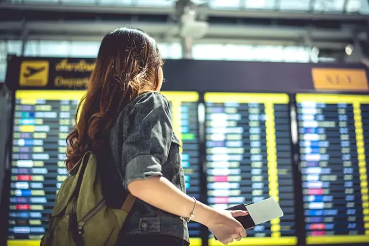 นักท่องเที่ยวกำลังดูตารางเที่ยวบินเพื่อตรวจสอบเวลาขึ้นเครื่อง นักท่องเที่ยวกำลังดูตารางเที่ยวบินเพื่อตรวจสอบเวลาขึ้นเครื่อง