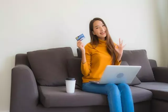 ผู้หญิงนั่งถือบัตรเครดิต
