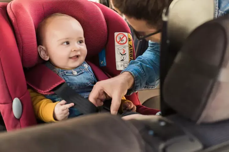 คุณพ่อกำลังจับลูกน้อยนั่งบนคาร์ซีท คุณพ่อกำลังจับลูกน้อยนั่งบนคาร์ซีท