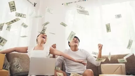 หนุ่มสาวยิ้มมีความสุขท่ามกลางธนบัตรที่โปรยปรายลงมา