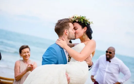 คู่บ่าวสาวจูบกันริมทะเล