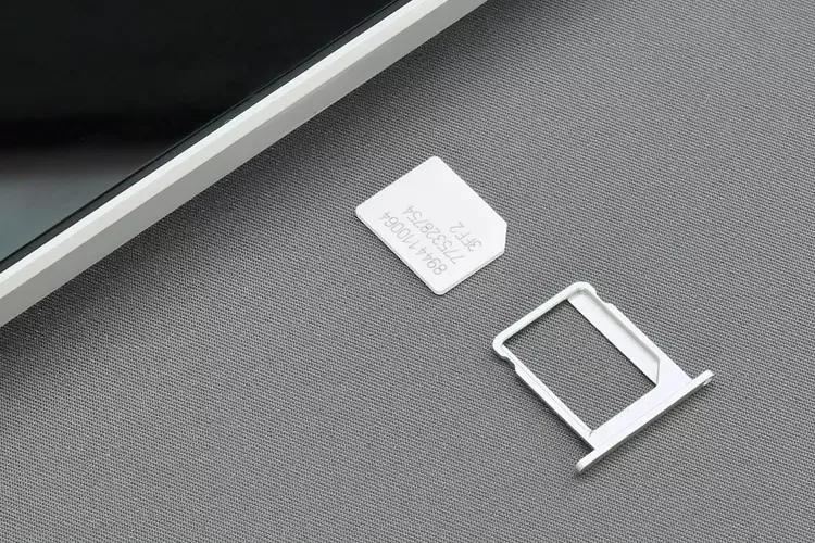 ถาดใส่ซิมการ์ดวางข้าง ๆ สมาร์ทโฟน 