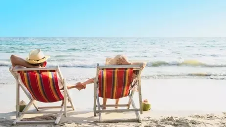 คู่รักนอนพักผ่อนที่เก้าอี้ชายหาดริมทะเล