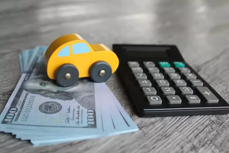 รถของเล่นวางอยู่บนธนบัตรที่ตั้งใกล้ ๆ กับเครื่องคิดเลข 