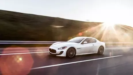 รถสปอร์ตสีขาวขับบนทางหลวง