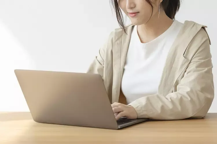 ผู้หญิงกำลังใช้งานโน้ตบุ๊กอยู่ที่บ้าน  