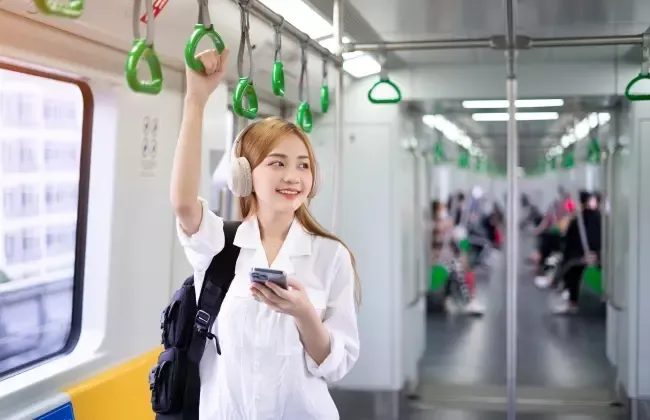 ผู้หญิงยืนอยู่บนรถไฟฟ้าใต้ดิน MRT