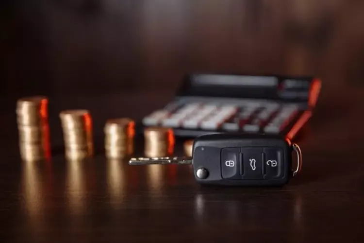 กุญแจรถวางอยู่หน้าเหรียญและเครื่องคิดเลขบนโต๊ะไม้ กุญแจรถวางอยู่หน้าเหรียญและเครื่องคิดเลขบนโต๊ะไม้