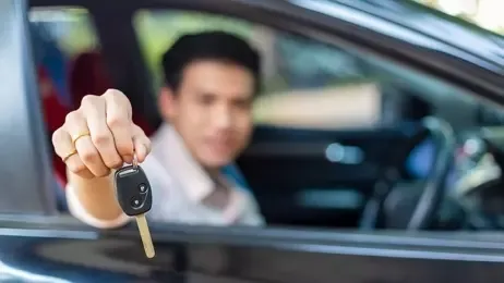 ผู้ชายยื่นกุญแจรีโมทออกมานอกรถยนต์