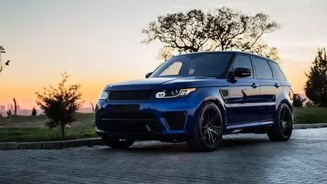 รถยนต์สีน้ำเงินอยู่ที่ลานจอดรถกลางแจ้ง