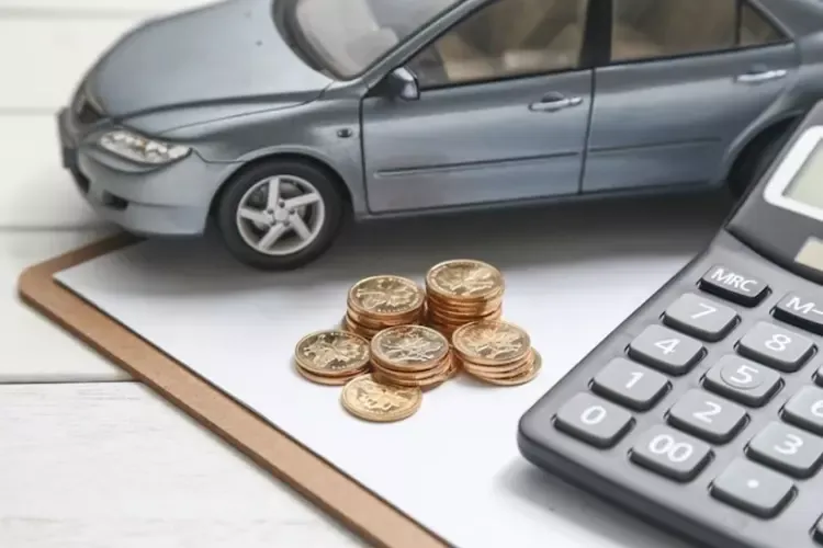 โมเดลรถ กองเหรียญ และเครื่องคิดเลขวางอยู่บนกระดาษสีขาว 