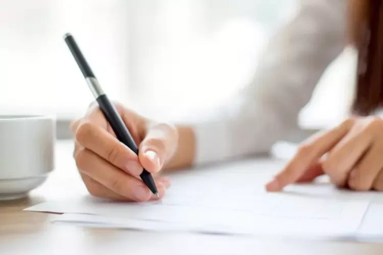 ผู้หญิงกำลังเซ็นเอกสาร 