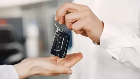 ผู้ชายกำลังส่งกุญแจรถให้ผู้หญิง