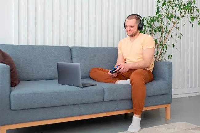 ผู้ชายกำลังนั่งเล่นเกมผ่านแล็ปท็อป ผู้ชายกำลังนั่งเล่นเกมผ่านแล็ปท็อป