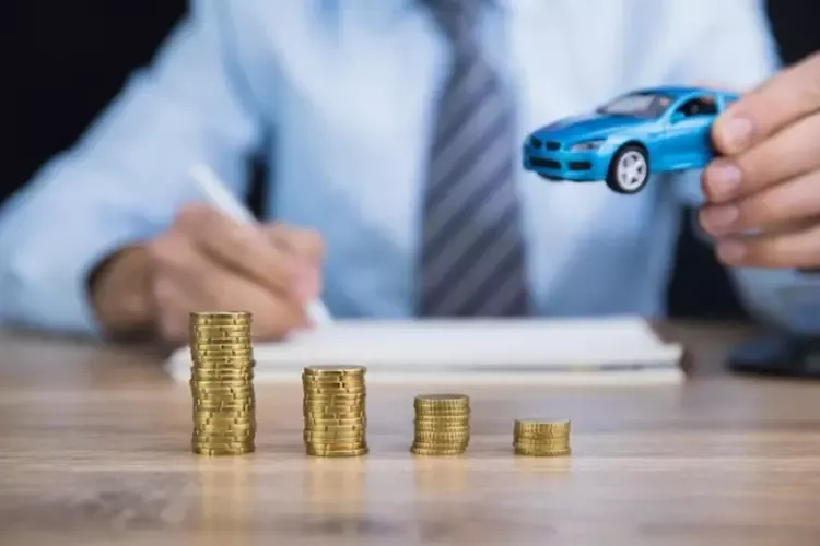 ผู้ชายถือรถของเล่นในมือและมีกองเหรียญวางอยู่ด้านหน้า ผู้ชายถือรถของเล่นในมือและมีกองเหรียญวางอยู่ด้านหน้า