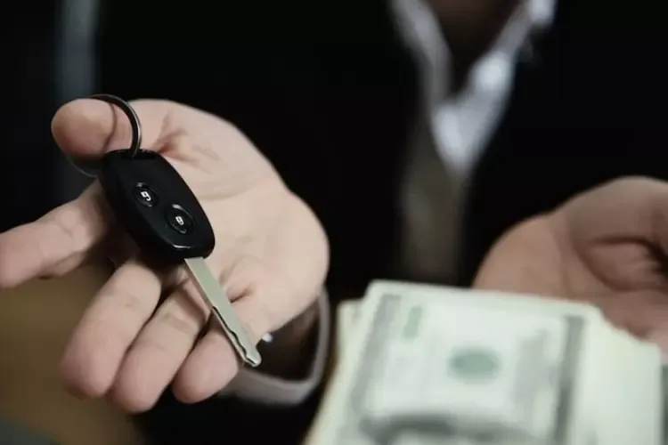 ผู้ชายโชว์กุญแจรถและธนบัตรในมือ ผู้ชายโชว์กุญแจรถและธนบัตรในมือ