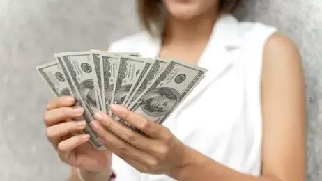 ผู้หญิงถือเงินธนบัตรในมือ