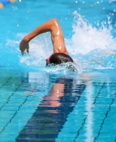 ผู้ชายกำลังว่ายน้ำในสระว่ายน้ำ 