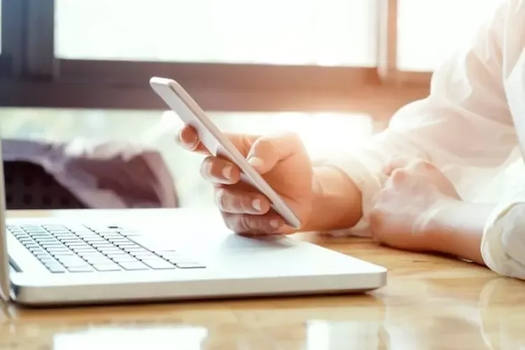 ผู้ชายใช้งานโน้ตบุ๊กและโทรศัพท์มือถือ ผู้ชายใช้งานโน้ตบุ๊กและโทรศัพท์มือถือ