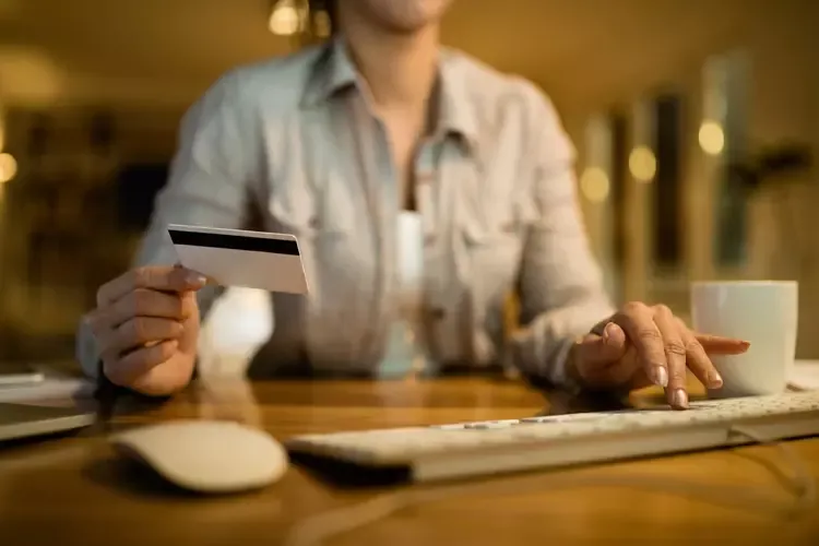 ผู้หญิงใช้คอมพิวเตอร์และบัตรเครดิต 