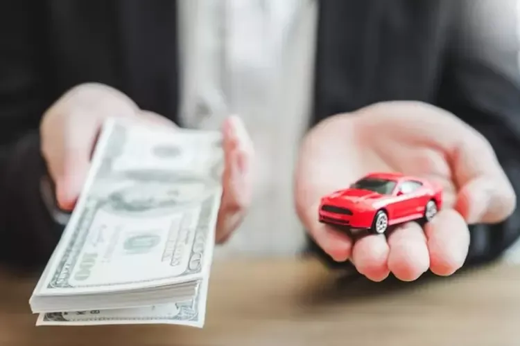 ผู้ชายถือรถของเล่นและธนบัตรในมือ 