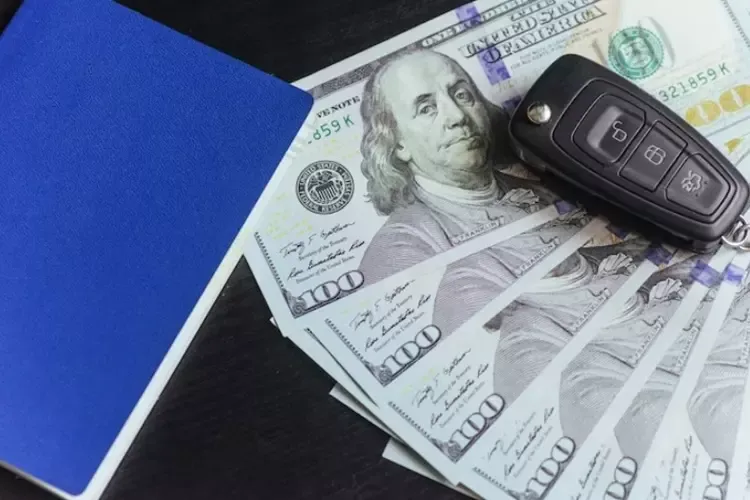 กุญแจรถและรถวางอยู่บนธนบัตร 100 ดอลลาร์ 
