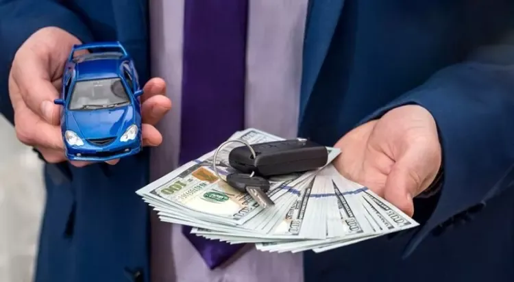 ผู้ชายถือกุญแจรถ รถของเล่น และเงิน 