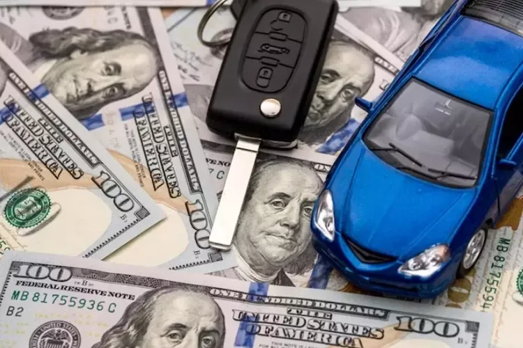 กุญแจรถวางบนธนบัตร 100 ดอลลาร์ อยู่ข้าง ๆ เล่มทะเบียน 