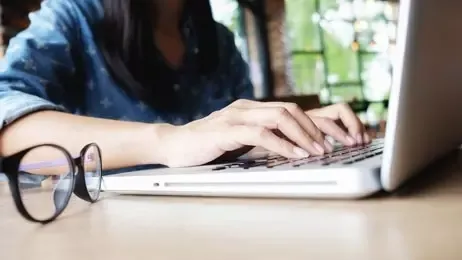 ผู้หญิงกำลังพิมพ์หาข้อมูลในโน้ตบุ๊ก