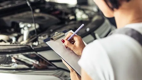 ผู้หญิงถือเอกสารในการเช็ครถ