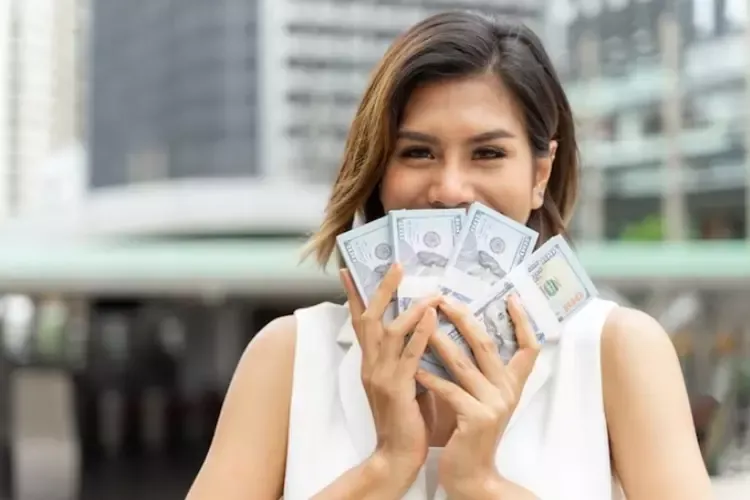 ผู้หญิงถือธนบัตรในมือ 
