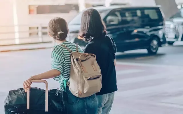 นักเดินทางผู้หญิง 2 คน กำลังรอรถรับส่ง นักเดินทางผู้หญิง 2 คน กำลังรอรถรับส่ง