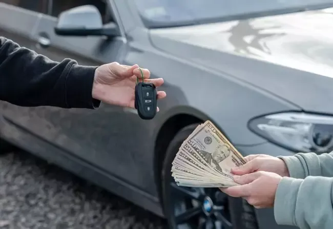 ถือกุญแจรถและเงิน 