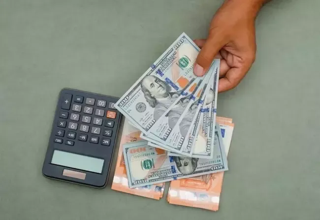 เครื่องคิดเลขและผู้ชายที่ถือธนบัตร 