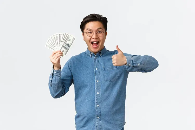 ผู้ชายถือธนบัตรหลายใบ