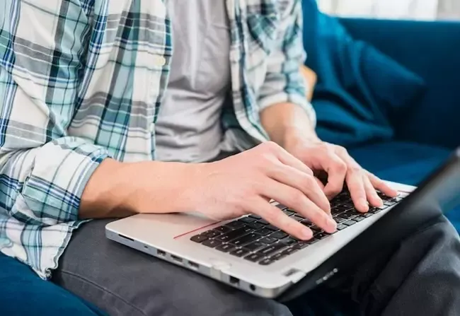 ผู้ชายใช้งานโน้ตบุ๊ก 