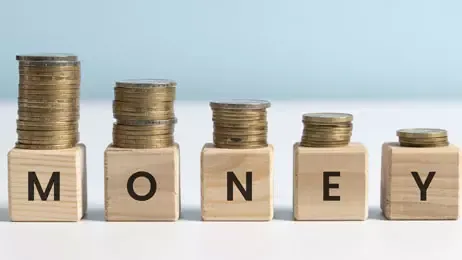 กองเหรียญวางบนลูกบาศก์ไม้