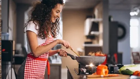 ผู้หญิงอยู่ในครัวกำลังทำอาหาร